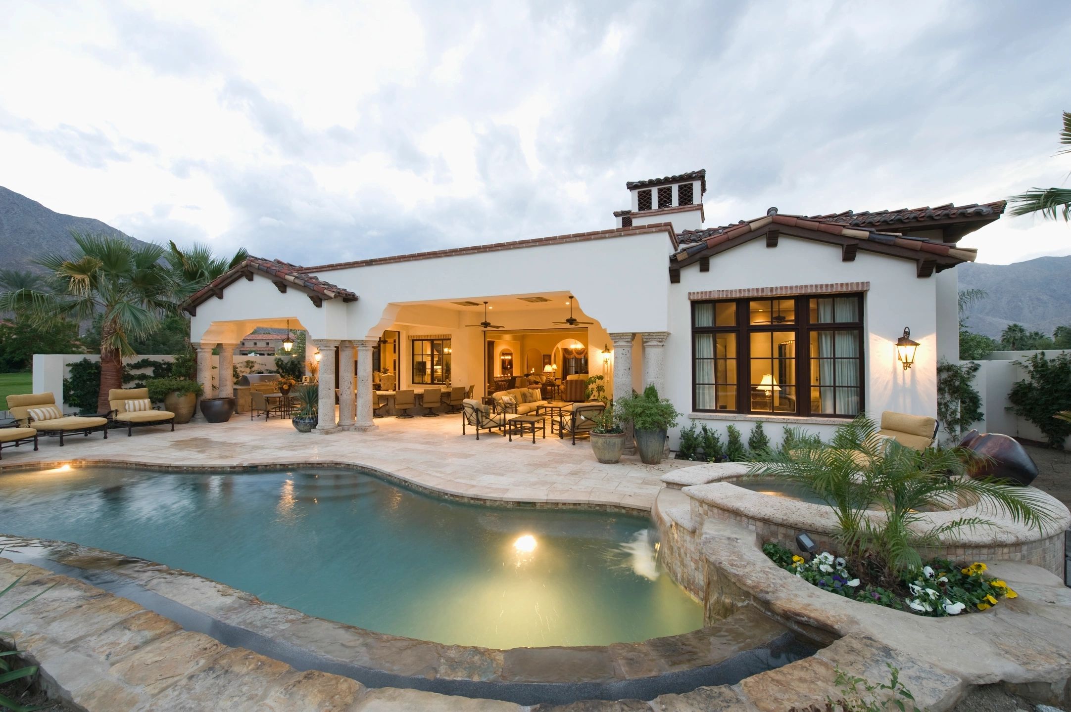 Spanish-style home with covered patio and pool at dusk - Premier Advantage Real Estate buyer rebate